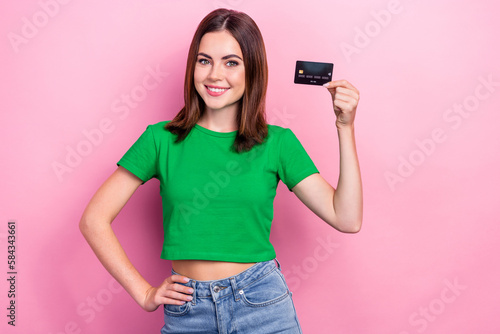 Photo of pretty cheerful lady arm hold showing plastic debit card isolated on pink color background