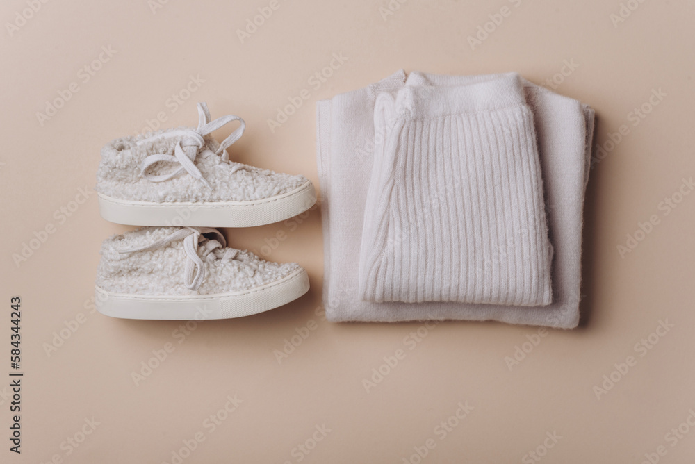 Baby boy knitted clothes, sweater, pants, shoes on beige background. Knitwear. Merino wool, cashmere concept Baby boy knitted clothes, sweater, pants, shoes on beige background. Knitwear. Merino wool, cashmere concept