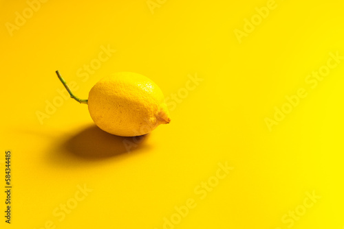 Eine ganze Zitrone auf einem gelben Hintergrund. Monochrom.