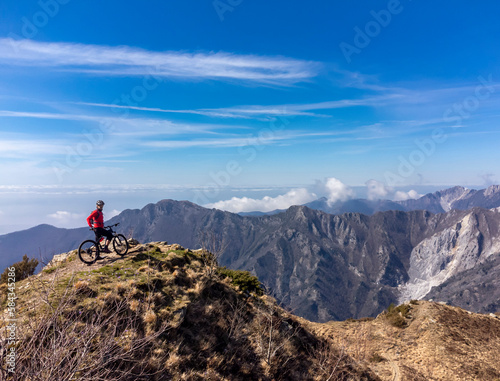 Un mountain biker su di una vetta delle Alpi Apuane in un giorno di primavera in Alta Versilia, Toscana.