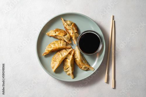 фотографія Fried dumplings gyoza with soy sauce, and chopsticks.