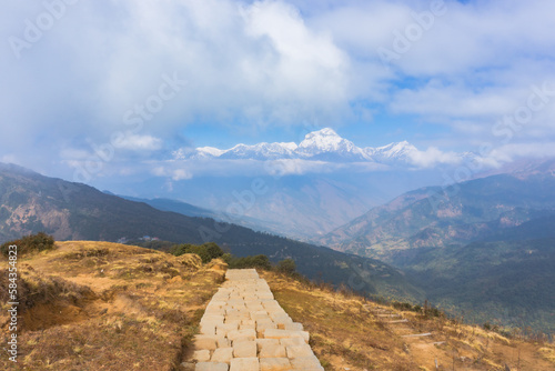 View of footway and countryside in Annapurna Base Camp Trek with Annapurna Mountain Range at background on the way from Ghorepani village to Tadapani village.  Amazing Himalayas in Nepal photo