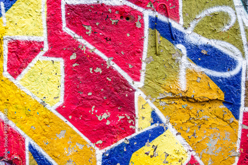 Abstract multicolored graffiti drawings. Wall painting yellow, red and blue. Cement background with texture.
