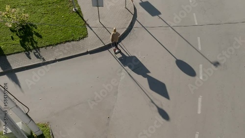 Aerial top view of a persom walking on the street and dragging a goods stroller photo