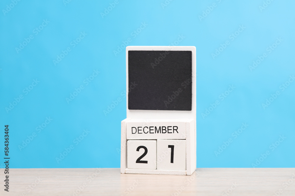 White wooden block monthly calendar with the date december 21 on the table, blue background. Planning, deadline White wooden block monthly calendar with the date december 21 on the table, blue background. Planning, deadline