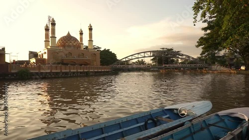the evening atmosphere in front of the Al Misbah Mosque which is passed by the Karang Mumus River, Samarinda photo