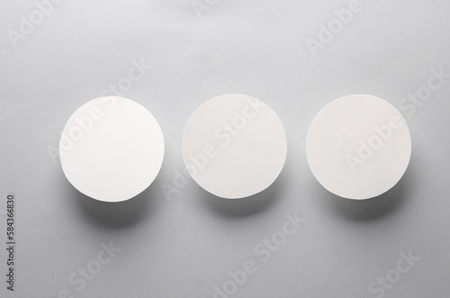 Mockup of white round coasters on a gray background. Template for design