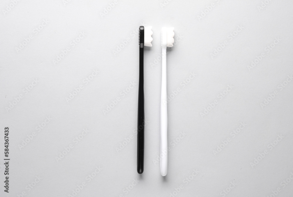 White and black toothbrushes on a white background. Top view. White and black toothbrushes on a white background. Top view.