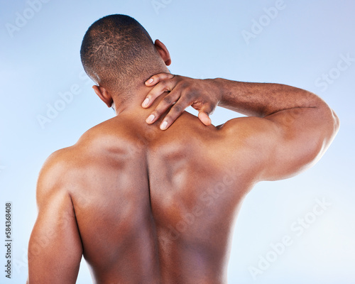 Black man, neck pain and injury with fitness and health, medical problem and aching body with back view. Emergency, muscle tension and male athlete with joint ache from workout on blue background