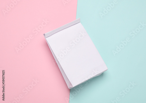 White paper lunch bag mockup on pink blue background. Template for design. Top view