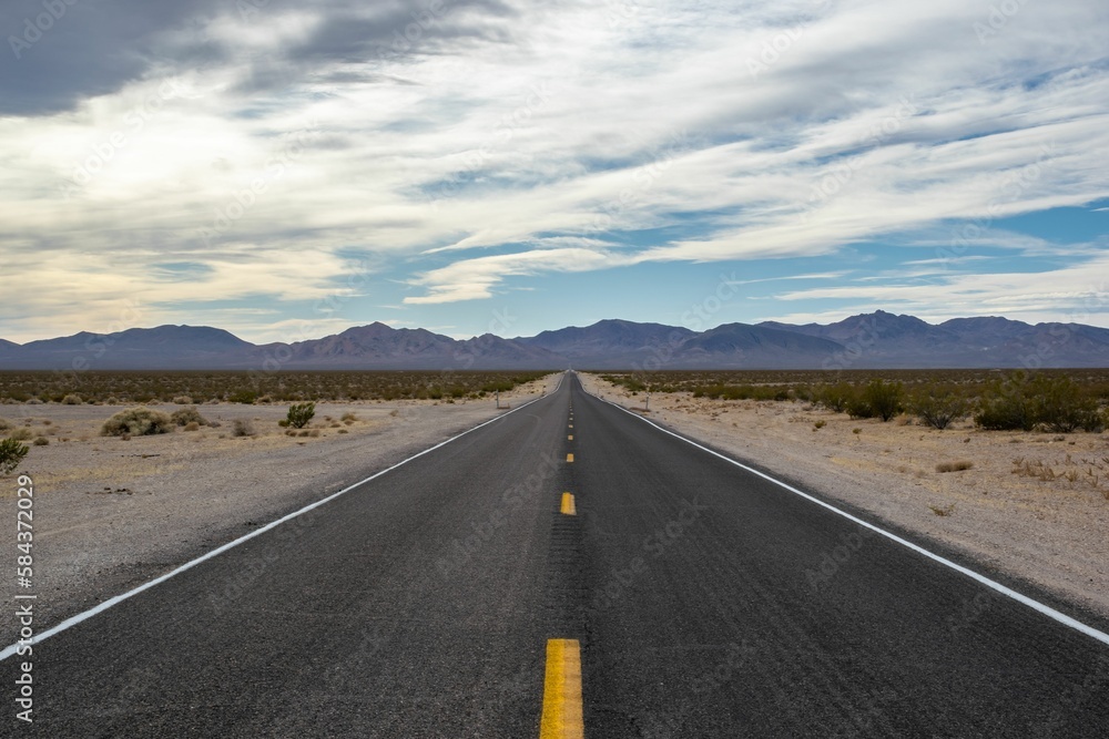 Beautiful shot of a highway between dry fields directed to Death Valley Beautiful shot of a highway between dry fields directed to Death Valley