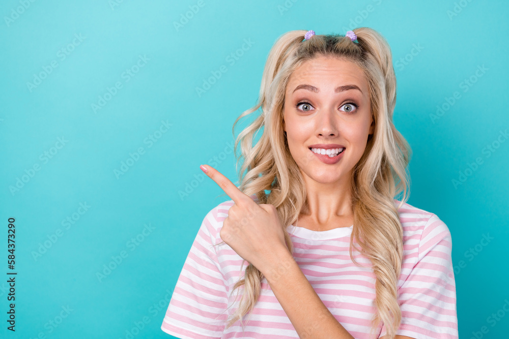 Photo of gorgeous person bite lips direct finger empty space ad promo isolated on teal color background Photo of gorgeous person bite lips direct finger empty space ad promo isolated on teal color background