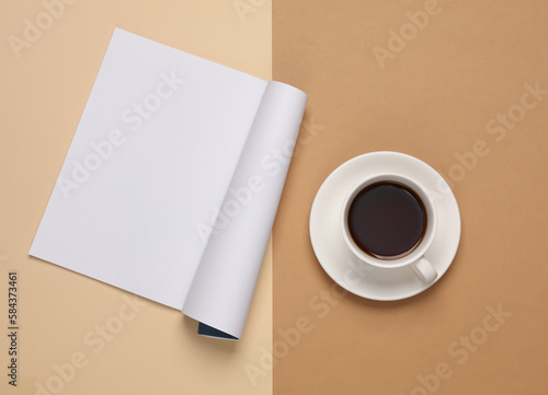 White blank magazine page mockup and coffee cup on brown background. Top view