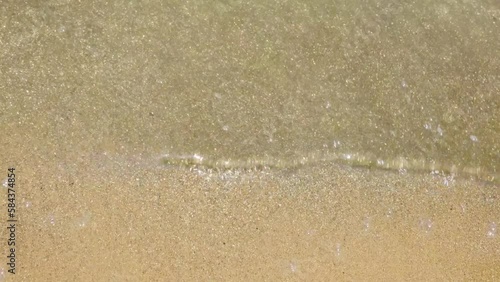 The golden water wave on the sand.