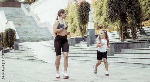 Active family concept. Fit mom and little daughter jogging outdoors. Healthy lifestyle. Spend time together