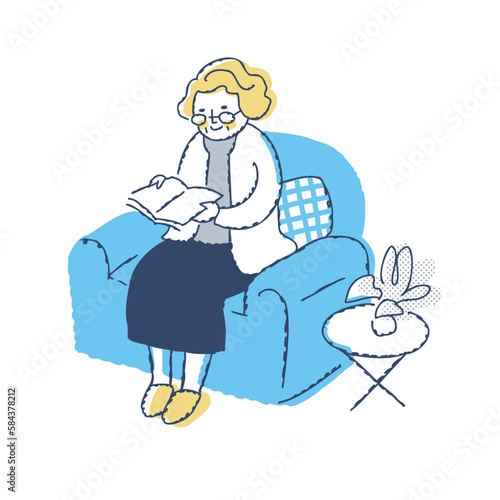 ソファーに座って本を読むシニア女性