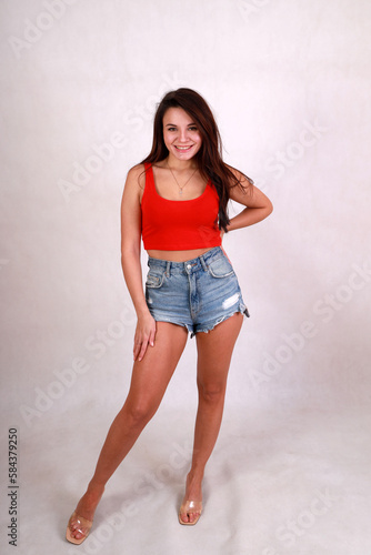 beautiful brunette in blue denim shorts and a red t-shirt