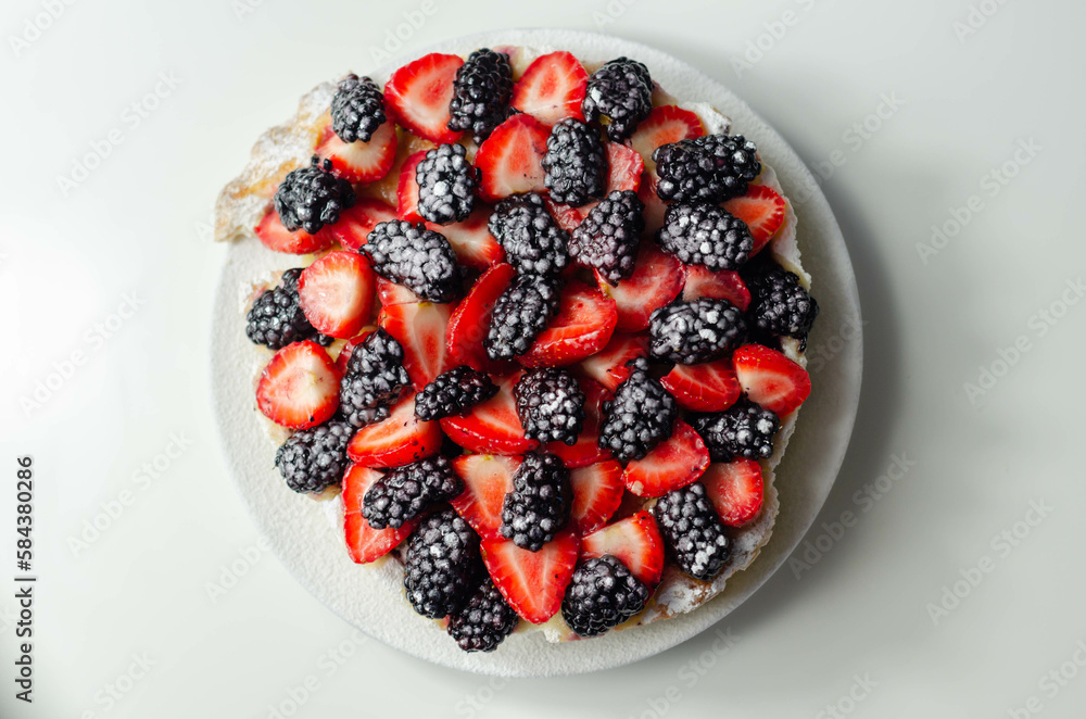 Butter enriched shortcrust pastry topped strawberries and blackberries, seasonal cake with colorful decoration Butter enriched shortcrust pastry topped strawberries and blackberries, seasonal cake with colorful decoration