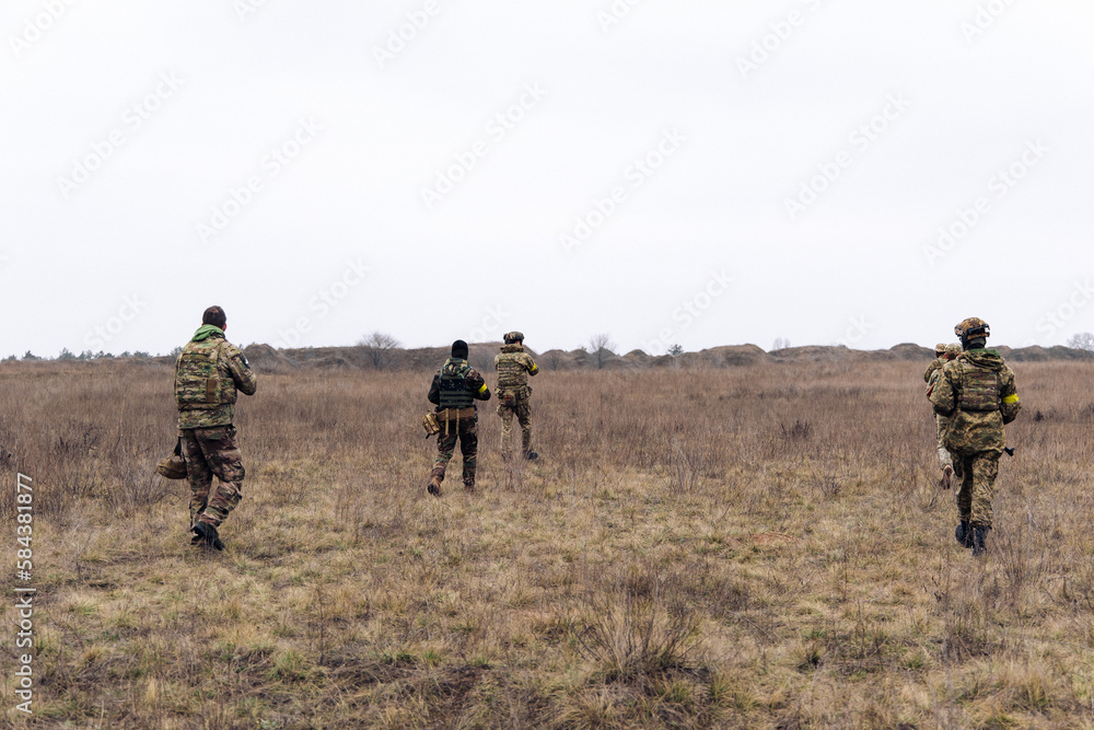 Group of armed Ukrainian soldiers walks through steppe. Group of armed Ukrainian soldiers walks through steppe.