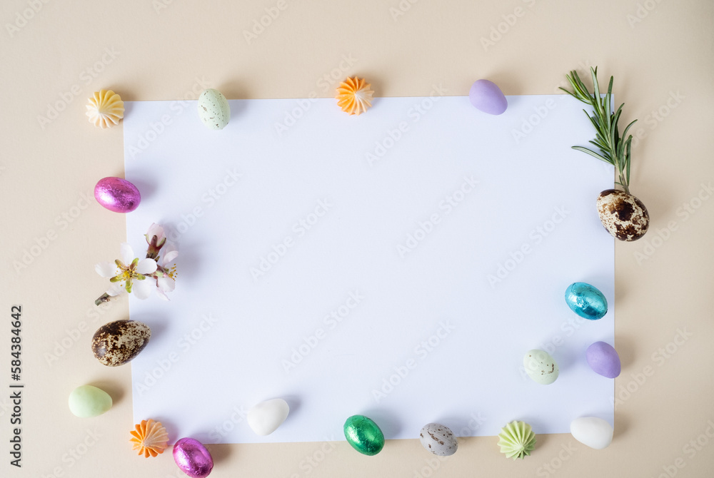 Creative Easter layout, chocolate and decoative eggs on a beige background.