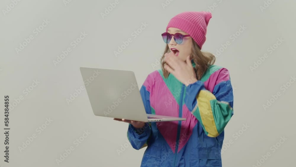 Extremely Happy, Satisfied Shocked Girl of '80-'90s Style With Pink Hat and Sunglasses Working on Laptop. Concept of Teenager and Technology, Modern Education, Teenager and the Internet Extremely Happy, Satisfied Shocked Girl of '80-'90s Style With Pink Hat and Sunglasses Working on Laptop. Concept of Teenager and Technology, Modern Education, Teenager and the Internet