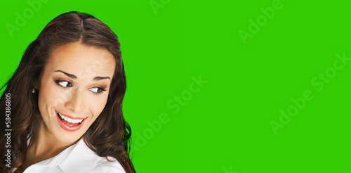 Happy excted smiling woman in white confident cloth looking aside. Business advertisement concept. Brunette businesswoman, isolated green chroma key background. photo