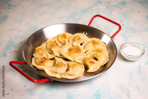 dumplings with potatoes and sour cream in a frying pan