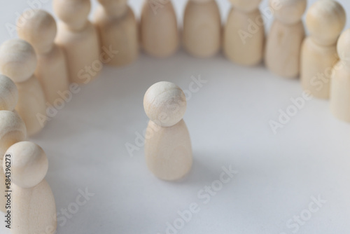 Wooden figurines stand on plain white surface of table