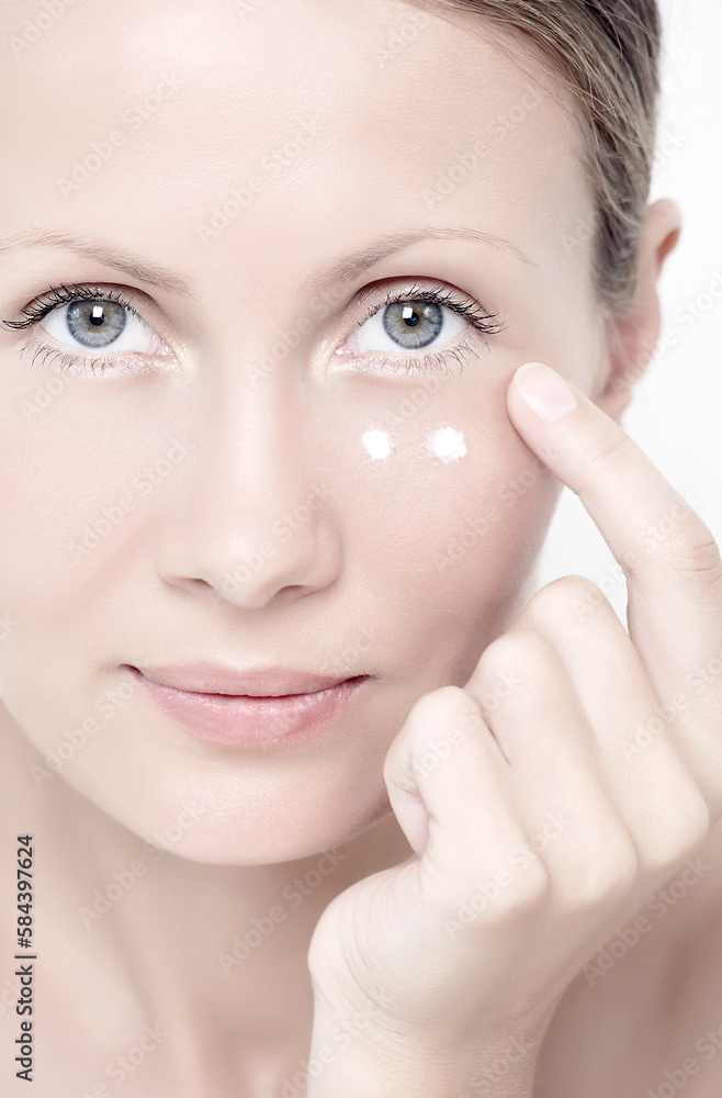 Young woman with cream under eyes Young woman with cream under eyes