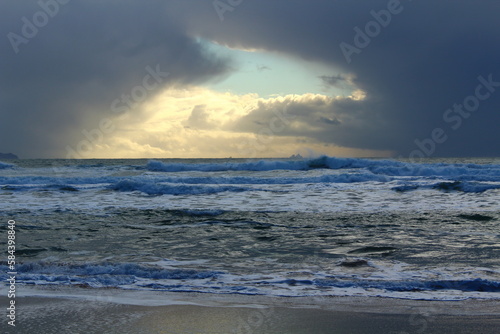 Warm yellow break in grey storm clouds over ocean  Kerry  Ireland 