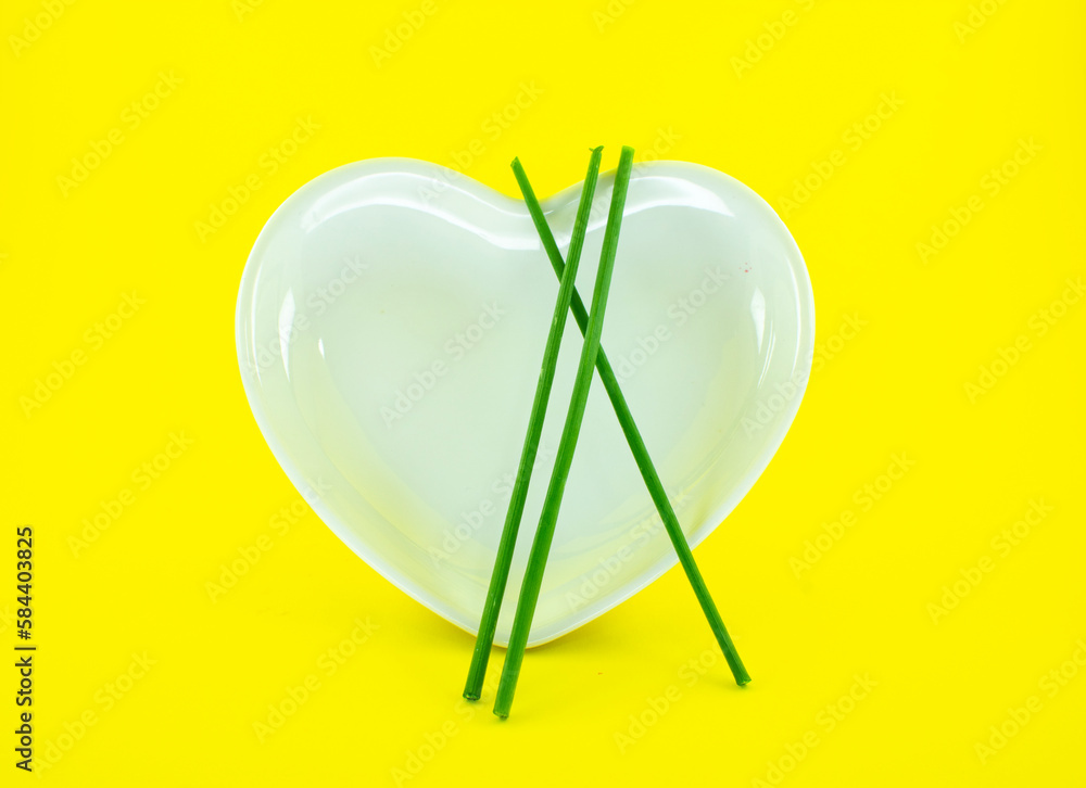 lindo prato branco em forma de coração e fundo amarelo lindo prato branco em forma de coração e fundo amarelo