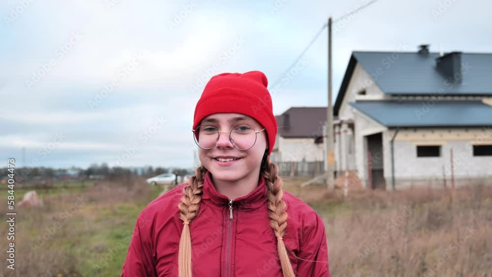 A teenage girl is walking down the street in good spirits in late autumn. A teenage girl is walking down the street in good spirits in late autumn.