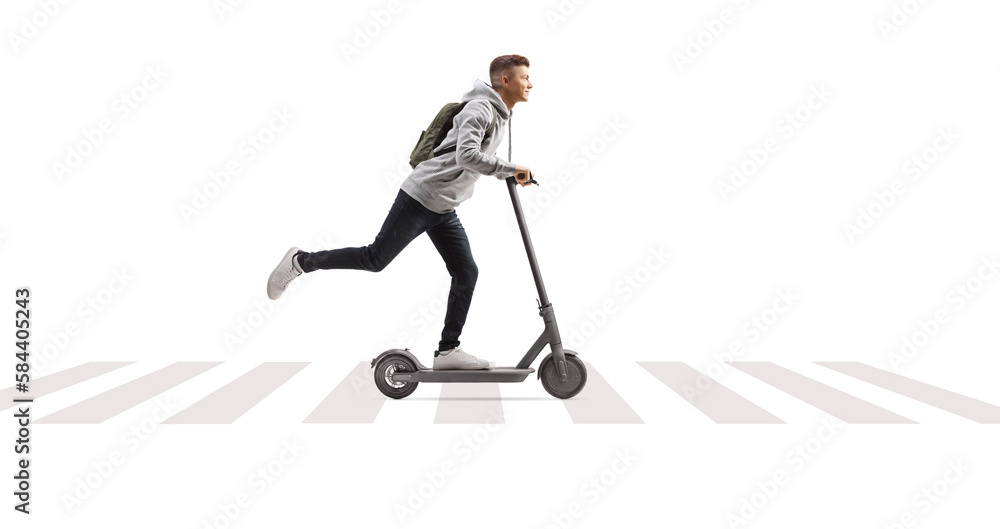 Obraz premium Full length shot of a male student with a backpack riding an electric scooter at pedestrian zebra crossing