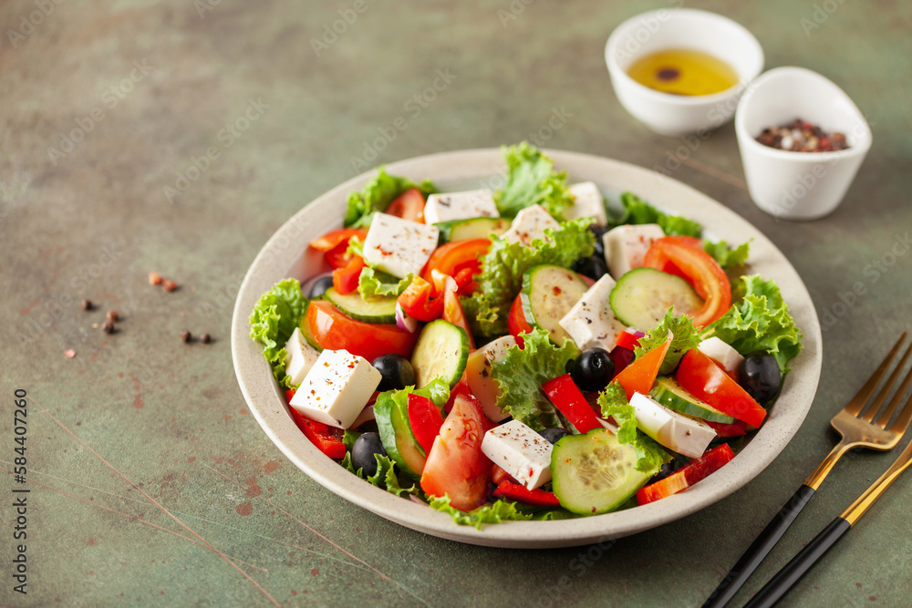 Greek salad of fresh cucumber, tomato, sweet pepper, lettuce, red onion, feta cheese and olives with olive oil. Healthy food