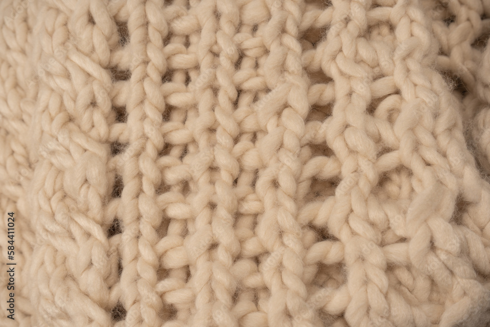 A fragment of beige knitted fabric, knitted from white sheep wool. A fragment of beige knitted fabric, knitted from white sheep wool.