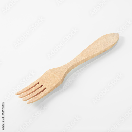 Wood kitchen utensils. Wooden fork on a white mirror background