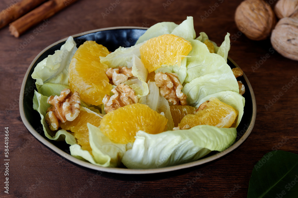 Orange salad with orange fruit, romaine lettuce and walnut nuts. Fresh, homemade salad. Orange salad with orange fruit, romaine lettuce and walnut nuts. Fresh, homemade salad.