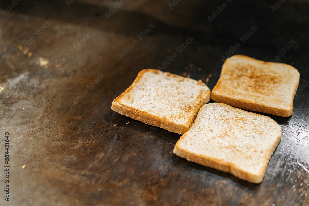 professional kitchen in hotel restaurant close-up of club sandwich toasts being grilled