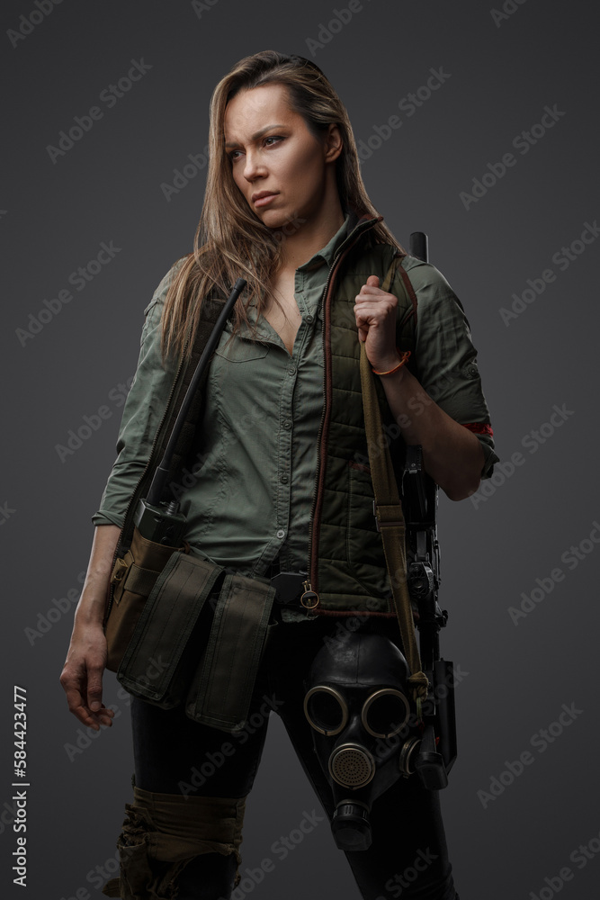 Portrait of military woman with rifle in post apocalyptic setting against grey background. Portrait of military woman with rifle in post apocalyptic setting against grey background.