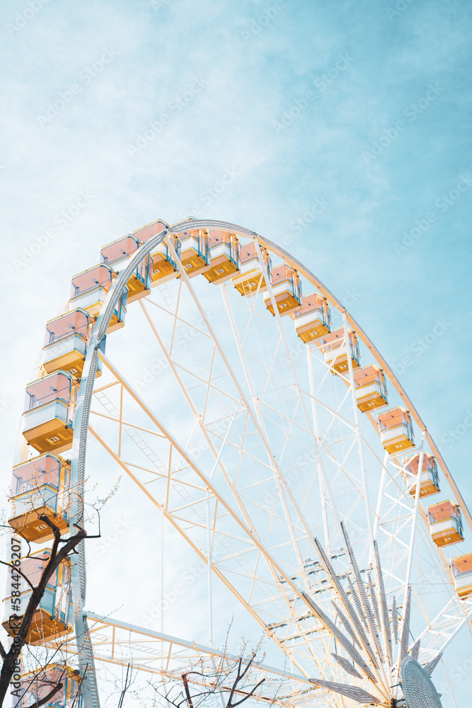 Colorful Ferris wheel in an amusement park with blue sky