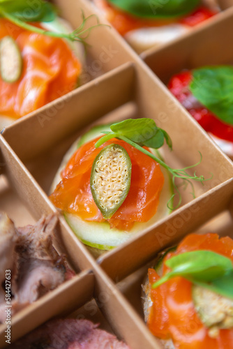 Gourmet snacks with red fish fillet delivered for food catering service in a cardboard box