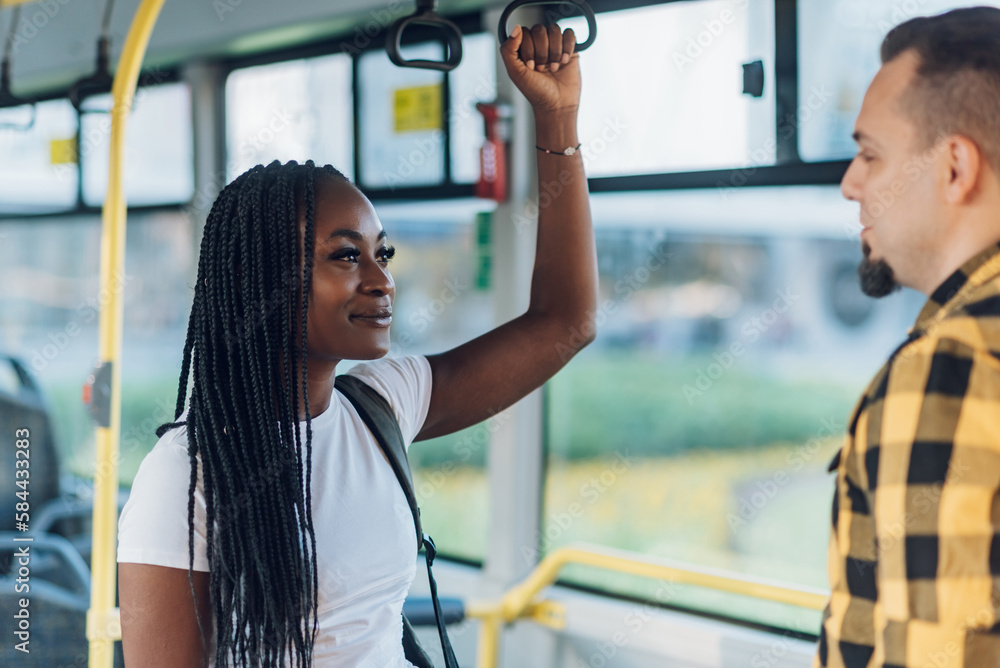 African american woman riding in a bus and holding a bar