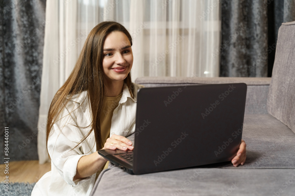 Beautiful young female freelancer working on a laptop at home.