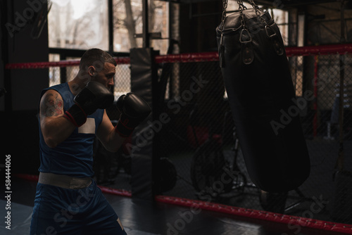 Boxing gym a boxer trains his punches hitting a punching bag