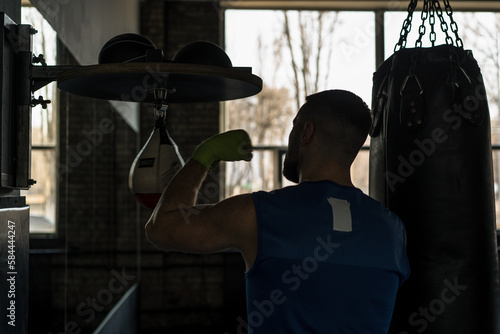 A boxer practicing a speed exercise with a small punching bag in a boxing gym