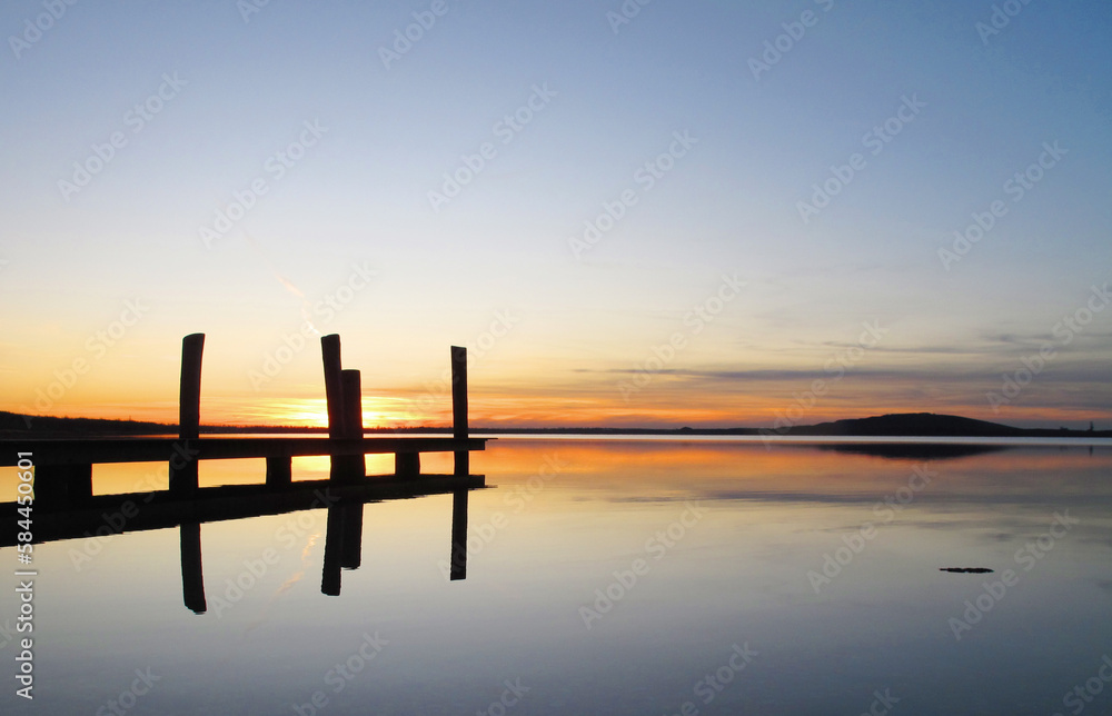 Beautiful lake in the evening with wooden jetty and still water Beautiful lake in the evening with wooden jetty and still water