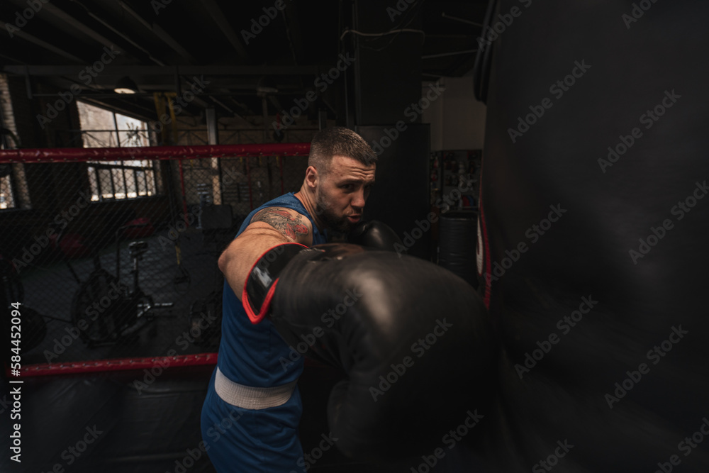 Boxing gym a boxer trains his punches hitting a punching bag