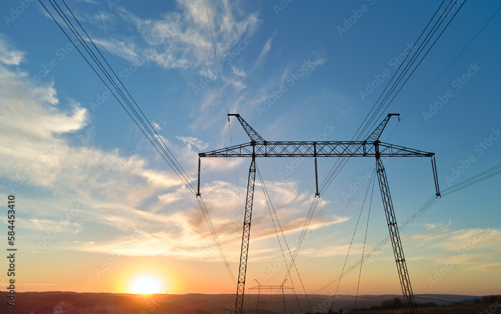 High voltage tower with electric power lines at sunset. Transmission of electricity