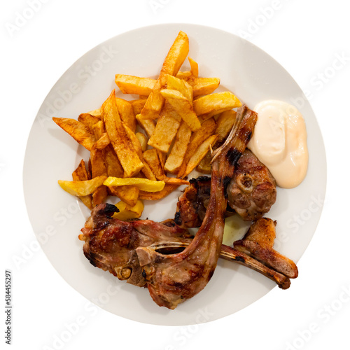 Delicious browned baked lamb ribs served with crispy french fries and creamy aioli sauce. Isolated over white background