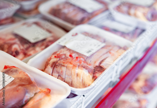 Sliced fresh raw chilled lamb meat in packages with labels on display in butcher shop..